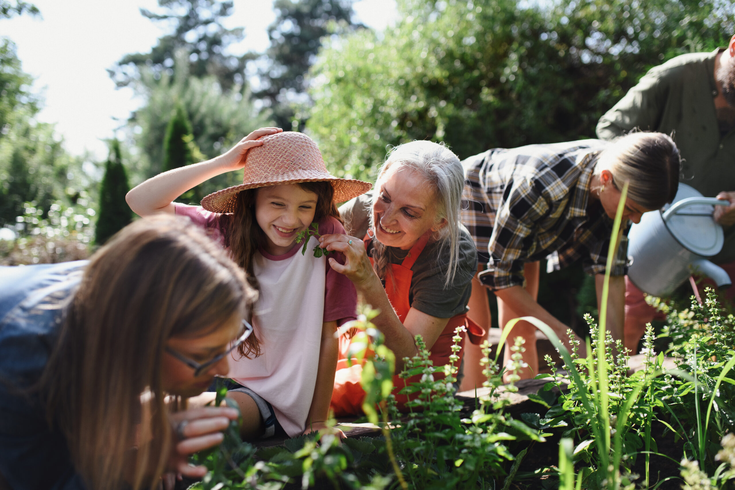 Image of several farmers of varying age gathering around in a garden